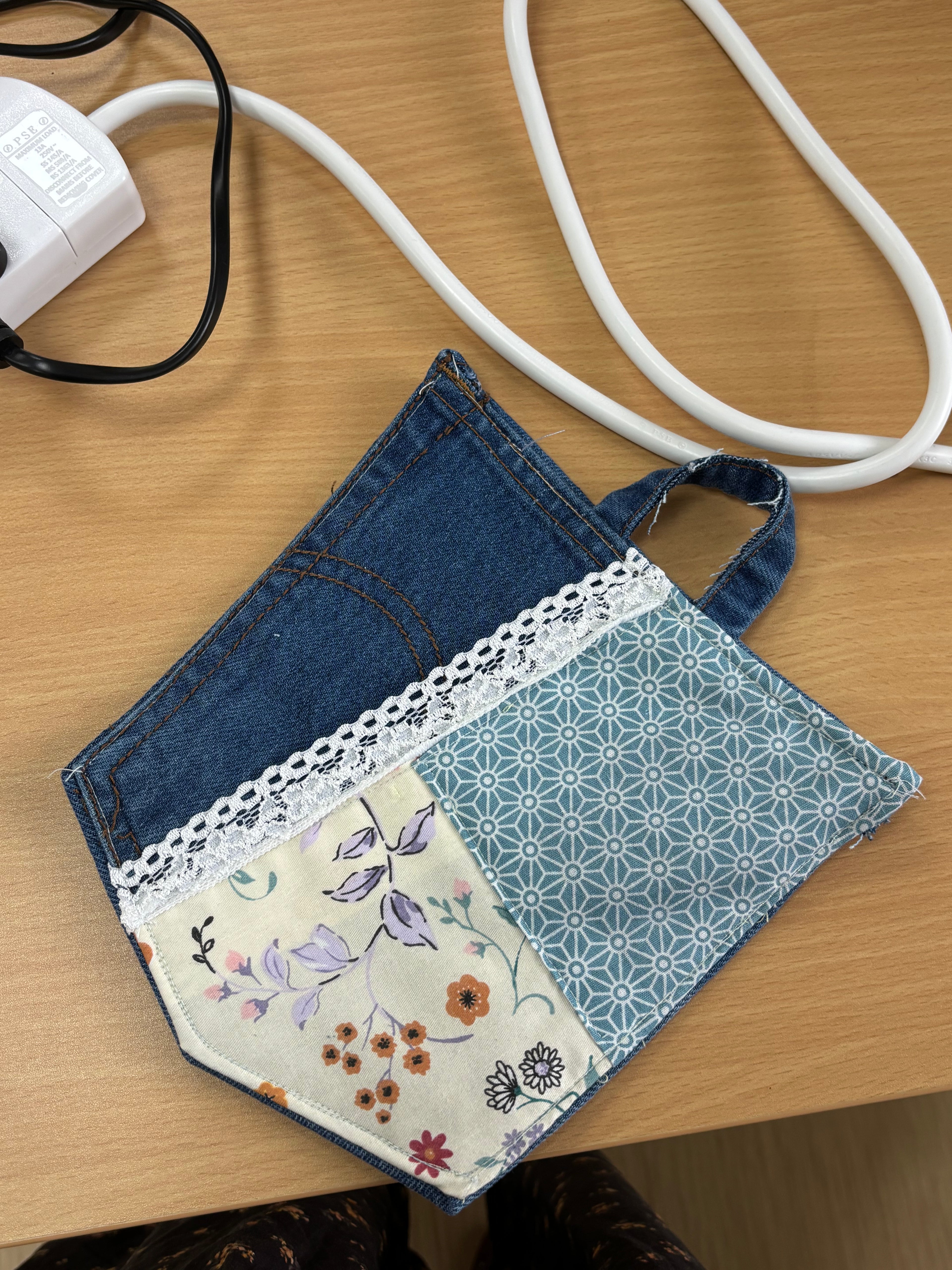 Handmade patchwork coaster featuring upcycled denim, floral fabric, blue geometric patterns, and white lace trim, created in a 2-hour sewing workshop