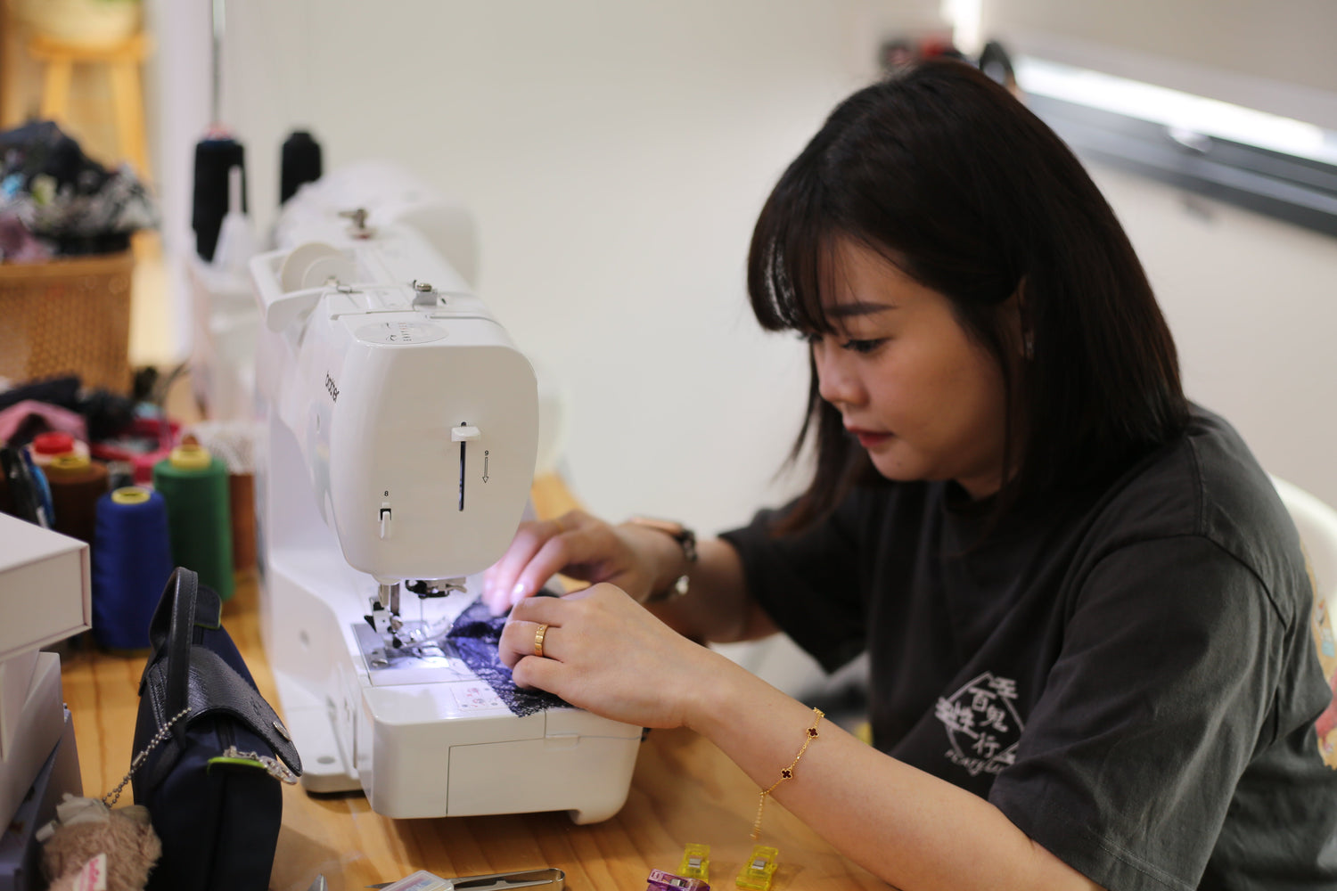 A maker carefully stitching black lace on a Brother sewing machine during a 2-pax besties intimate wear workshop.