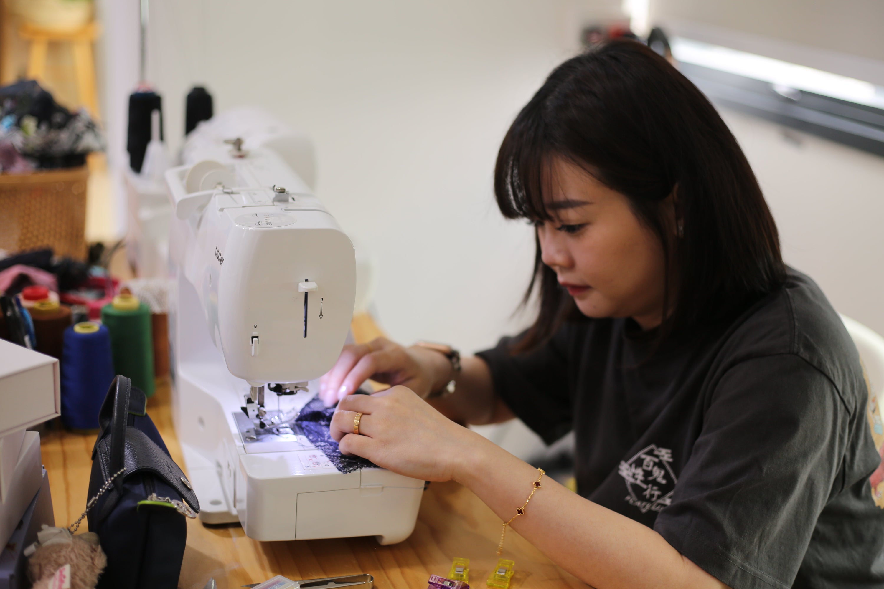 A maker carefully stitching black lace on a Brother sewing machine during a 2-pax besties intimate wear workshop.
