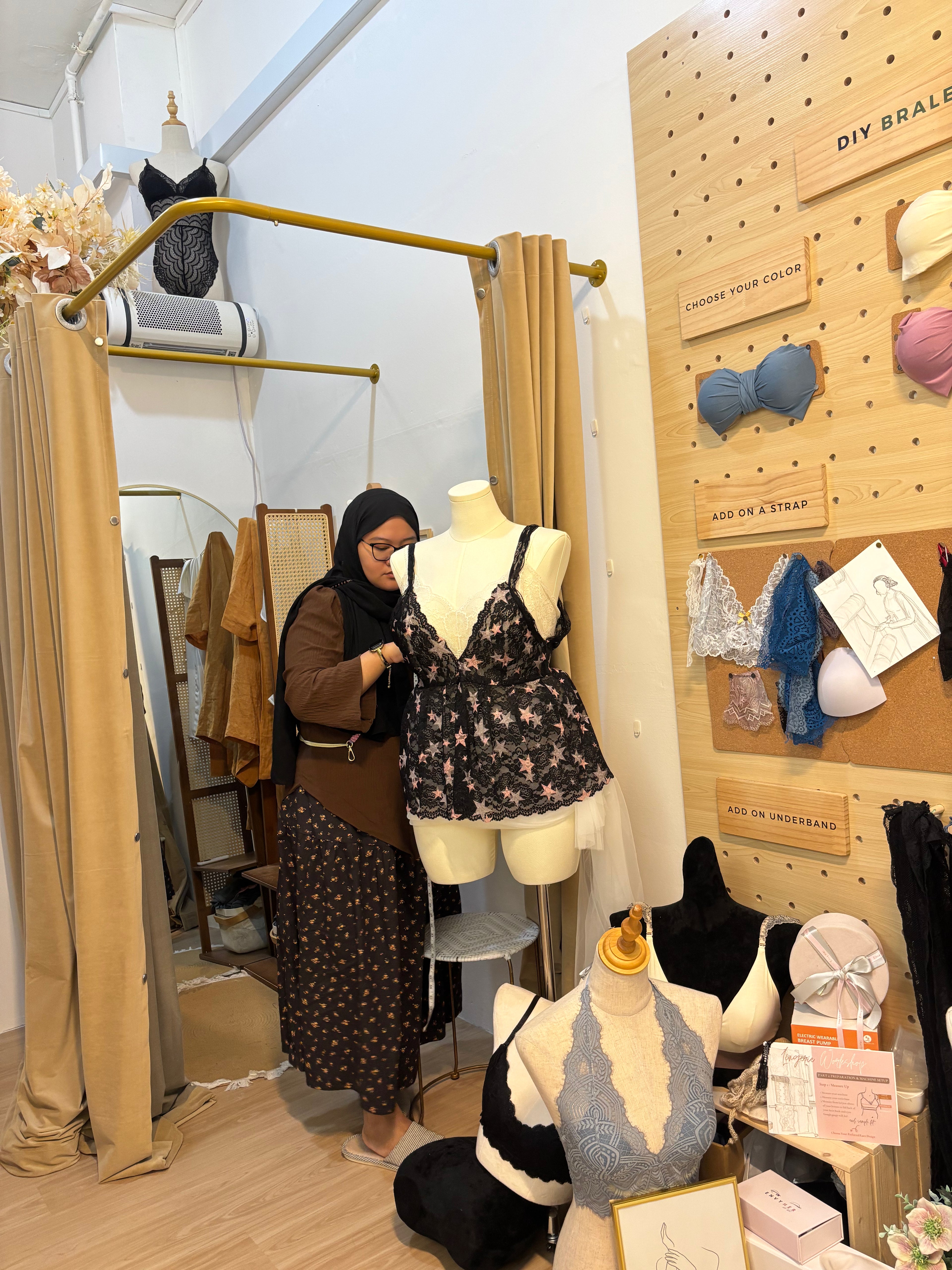 adjusting the gathers of a handmade babydoll top on a sewing machine during an apparel construction workshop