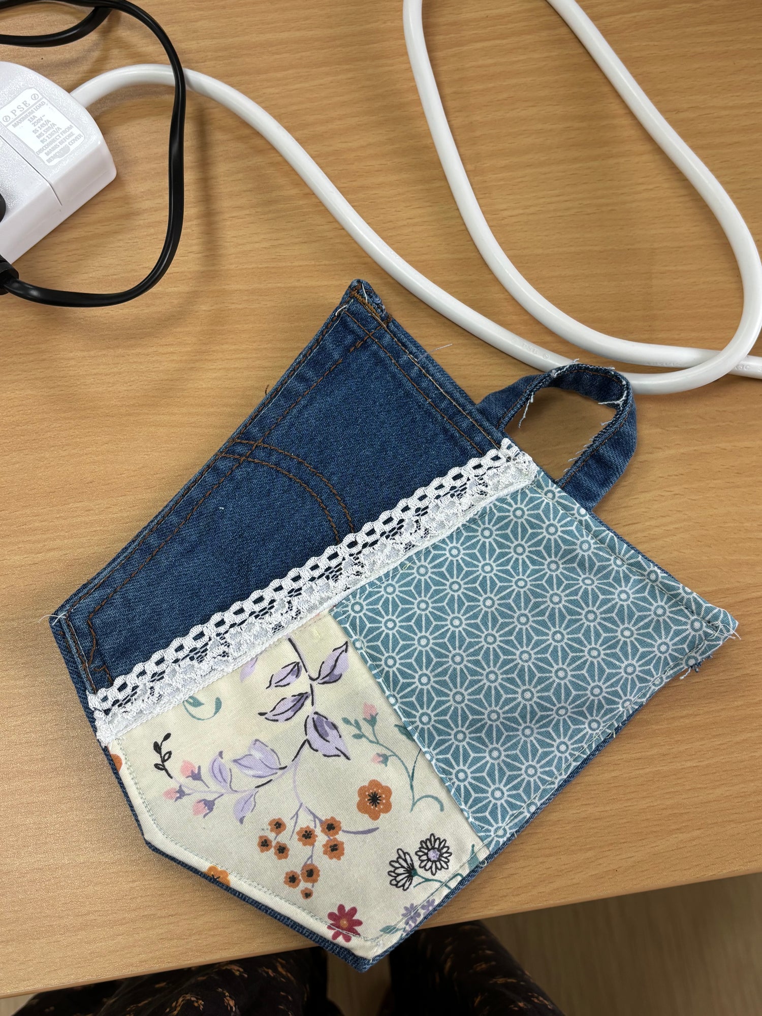 Handmade patchwork coaster featuring upcycled denim, floral fabric, blue geometric patterns, and white lace trim, created in a 2-hour sewing workshop