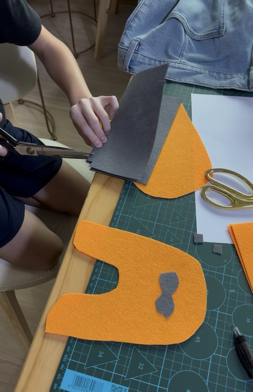 Child cutting fabric pieces with guidance from Jeannie at Envy Her Singapore&