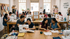 A diverse group of makers focused on their individual sewing machines during an intensive full-day craft workshop