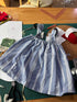 Close-up of a handmade striped pinafore dress set worn by a child, showcasing garment construction skills learned in a kids sewing class